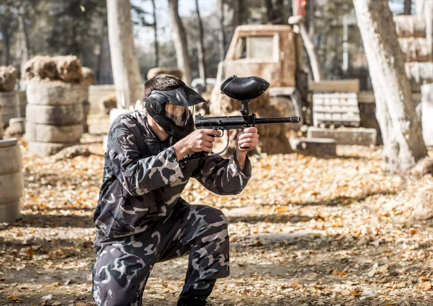 Giocatore adulto che prende la mira con il marcatore da paintball